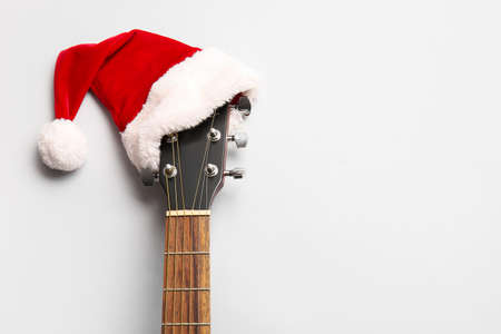 Guitar with Santa Claus hat on light backgroundの写真素材