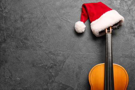 Violin with Santa Claus hat on dark backgroundの写真素材