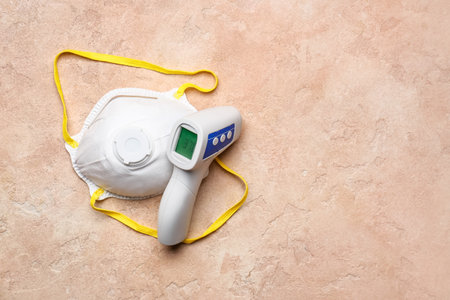Infrared thermometer with protective mask on color background