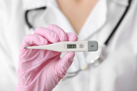 Doctor with electronic thermometer, closeupの写真素材
