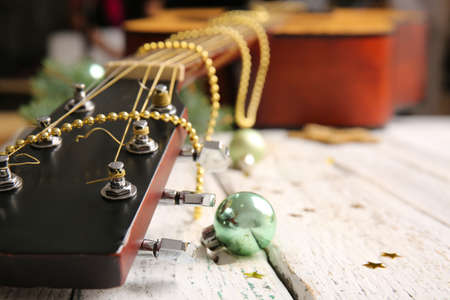 Guitar with Christmas decor on white wooden background, closeupの写真素材