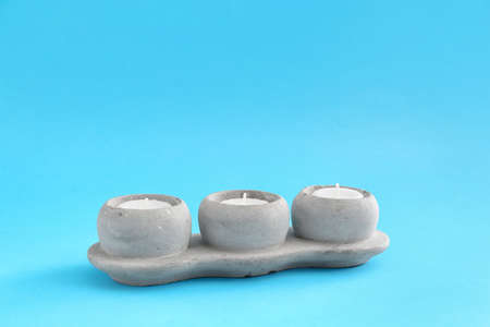 Candle holders on color background