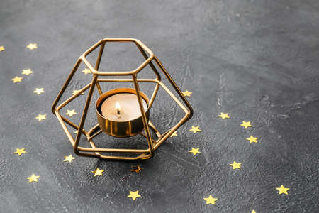 Burning candle in holder on dark backgroundの写真素材