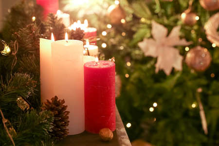 Burning candles on mantelpiece decorated for Christmasの写真素材