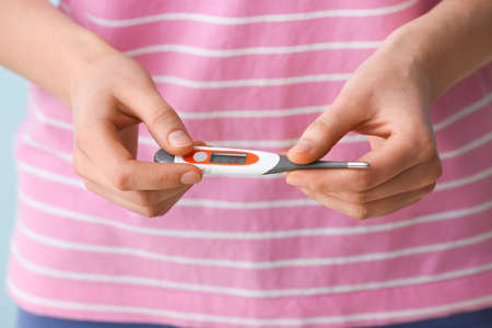 Woman with electronic thermometer, closeup