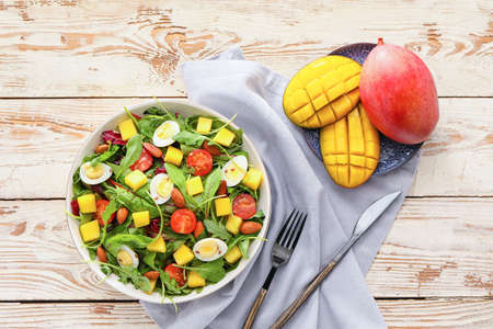 Plate of fresh mango salad on wooden backgroundの写真素材