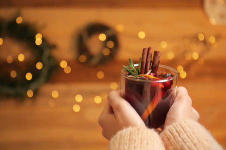 Woman with tasty mulled wine in room decorated for Christmasの写真素材