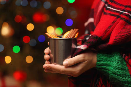 Woman with tasty mulled wine against blurred Christmas lightsの写真素材