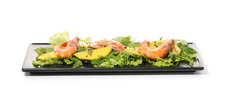 Plate of fresh mango salad with shrimps on white backgroundの写真素材