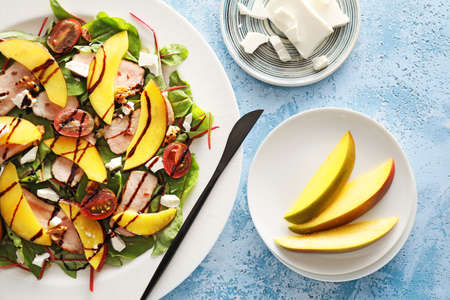 Plate of fresh mango salad on color backgroundの写真素材