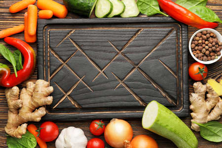 Cutting board with vegetables on wooden backgroundの写真素材