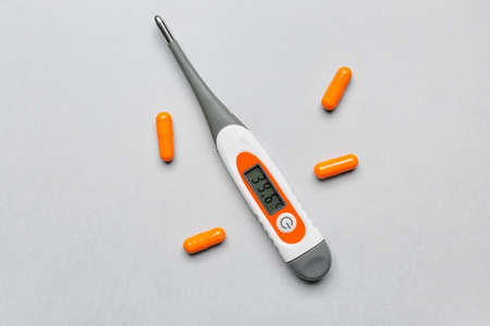 Thermometer and pills on light backgroundの写真素材