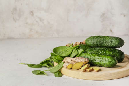 Cutting board with cucumber and ginger on light wooden backgroundの写真素材