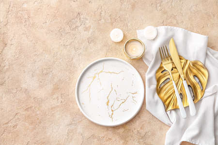 Beautiful table setting with burning candles on color background