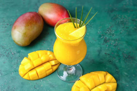 Glass of tasty mango margarita on color background