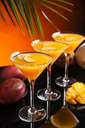 Glasses of tasty mango margarita on dark backgroundの写真素材