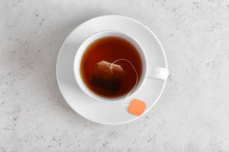 Cup of aromatic black tea on light backgroundの写真素材