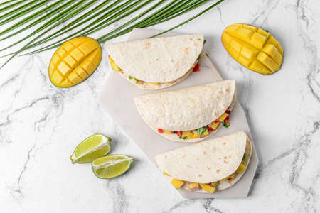 Tasty tacos with fresh mango salsa on light backgroundの写真素材