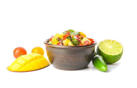 Bowl with fresh mango salsa on white backgroundの写真素材