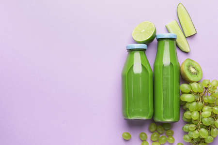 Composition with bottles of healthy green smoothie and ingredients on color backgroundの写真素材