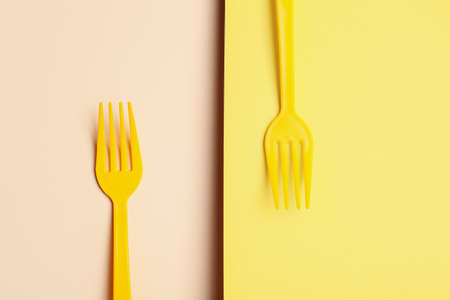 Plastic forks on color background