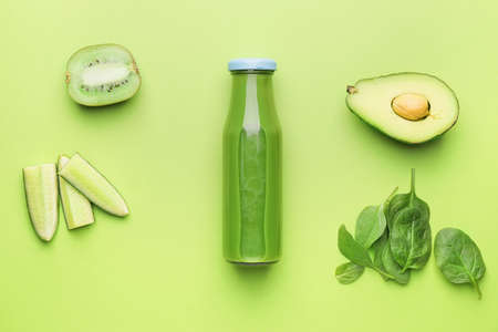 Composition with bottle of healthy green smoothie and ingredients on color backgroundの写真素材