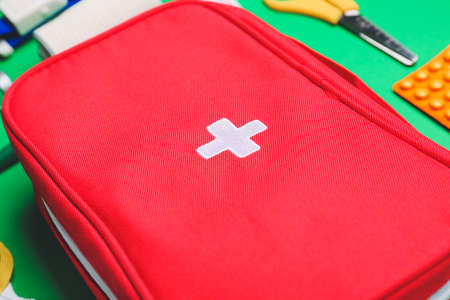 First aid kit on color background