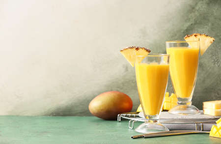 Glasses with tasty mango smoothie on color backgroundの写真素材