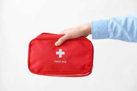 Female hand with first aid kit on white background