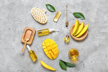 Composition with mango essential oil and bath supplies on gray backgroundの写真素材