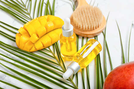 Bottles of mango essential oil on light background, closeupの写真素材