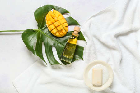Composition with mango essential oil and soap on light backgroundの写真素材
