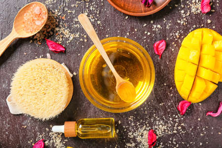 Composition with mango essential oil and bath supplies on dark backgroundの写真素材