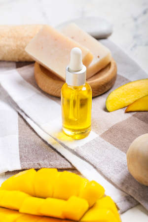 Composition with mango essential oil and bath supplies on tableの写真素材