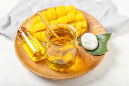 Composition with mango essential oil on light background, closeupの写真素材