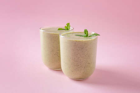 Glasses of tasty kiwi smoothie on color backgroundの写真素材