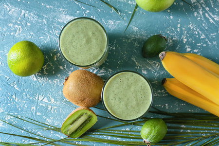 Glasses of tasty fruit smoothie on color backgroundの写真素材