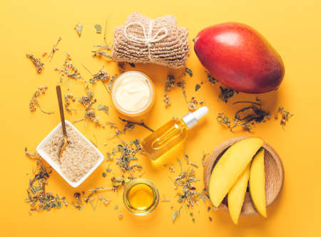 Composition with mango essential oil and bath supplies on color backgroundの写真素材