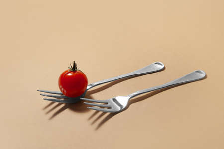Tomato and forks on color backgroundの写真素材
