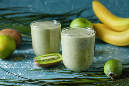 Glasses of tasty fruit smoothie on color backgroundの写真素材