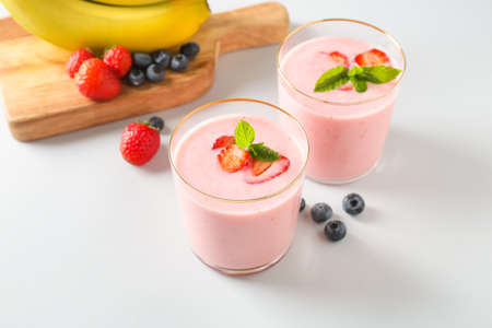 Glasses of tasty berry smoothie on light backgroundの写真素材