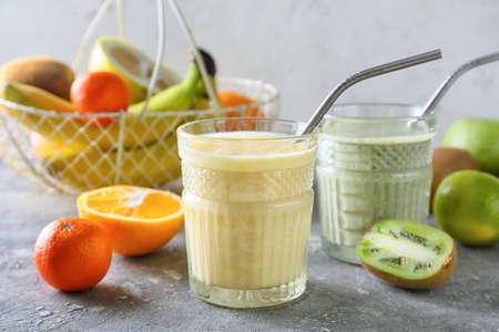 Glasses of tasty fruit smoothie on grunge backgroundの写真素材