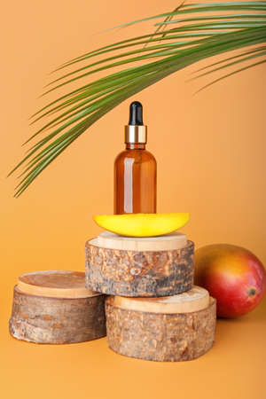Composition with mango essential oil on color backgroundの写真素材