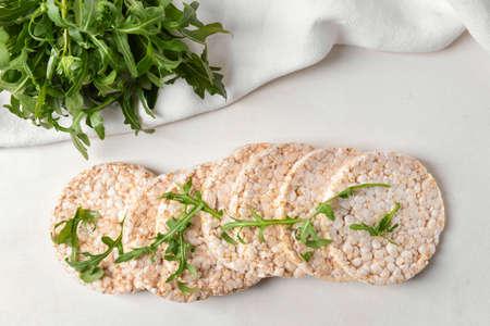 Rice crackers with arugula on light backgroundの写真素材