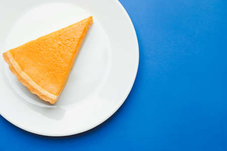 Plate with slice of tasty pumpkin pie on color backgroundの写真素材