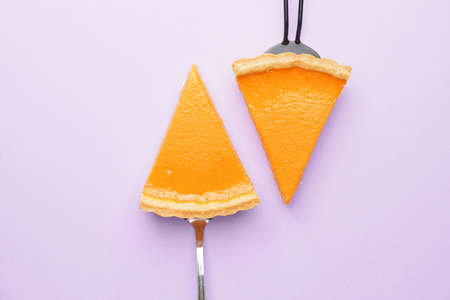 Slices of tasty pumpkin pie on color backgroundの写真素材