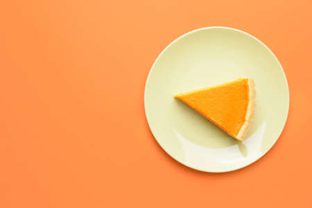 Plate with slice of tasty pumpkin pie on color backgroundの写真素材