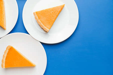 Plates with slices of tasty pumpkin pie on color backgroundの写真素材