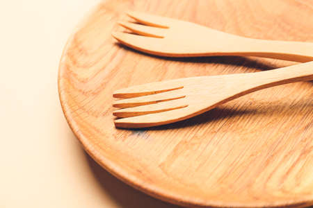 Wooden forks and plate on color backgroundの写真素材