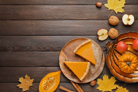 Composition with tasty cut pumpkin pie on wooden backgroundの写真素材